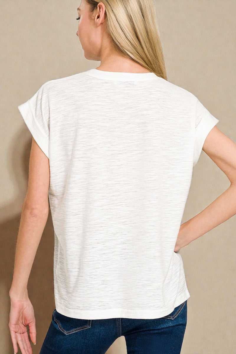 Woman wearing a white t-shirt and blue jeans against a beige background