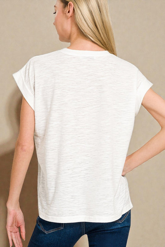 Woman wearing a white t-shirt and blue jeans against a beige background