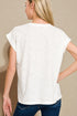 Woman wearing a white t-shirt and blue jeans against a beige background
