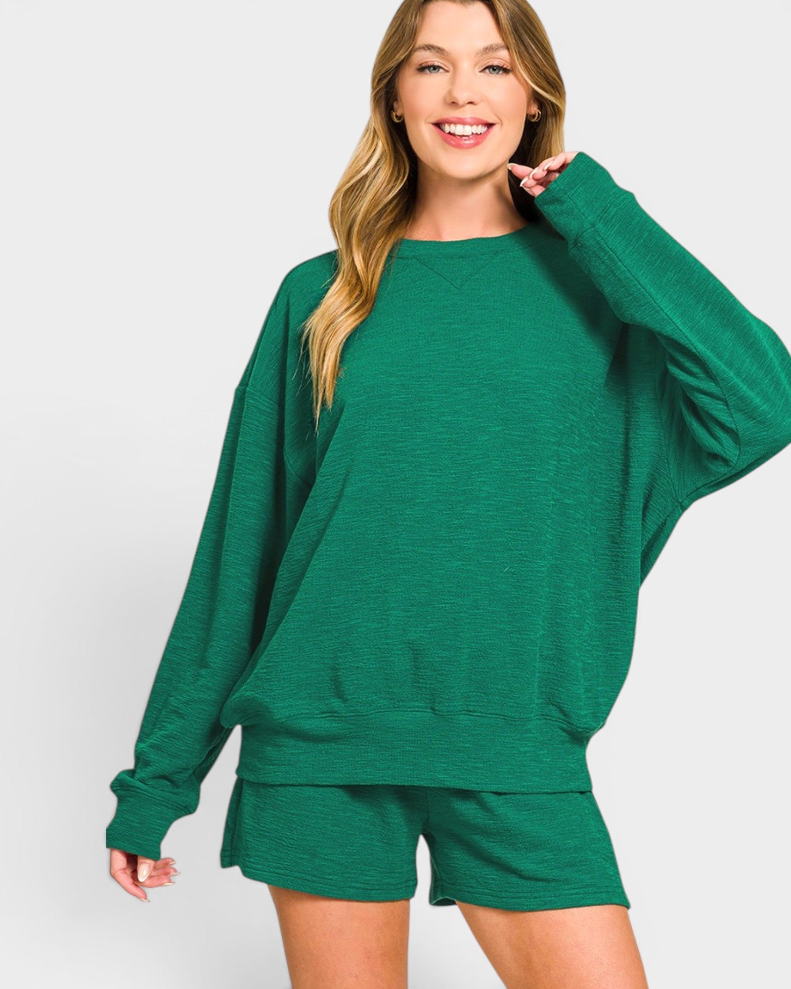 Woman wearing a green sweatshirt and shorts set on a white background