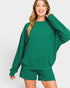 Woman wearing a green sweatshirt and shorts set on a white background