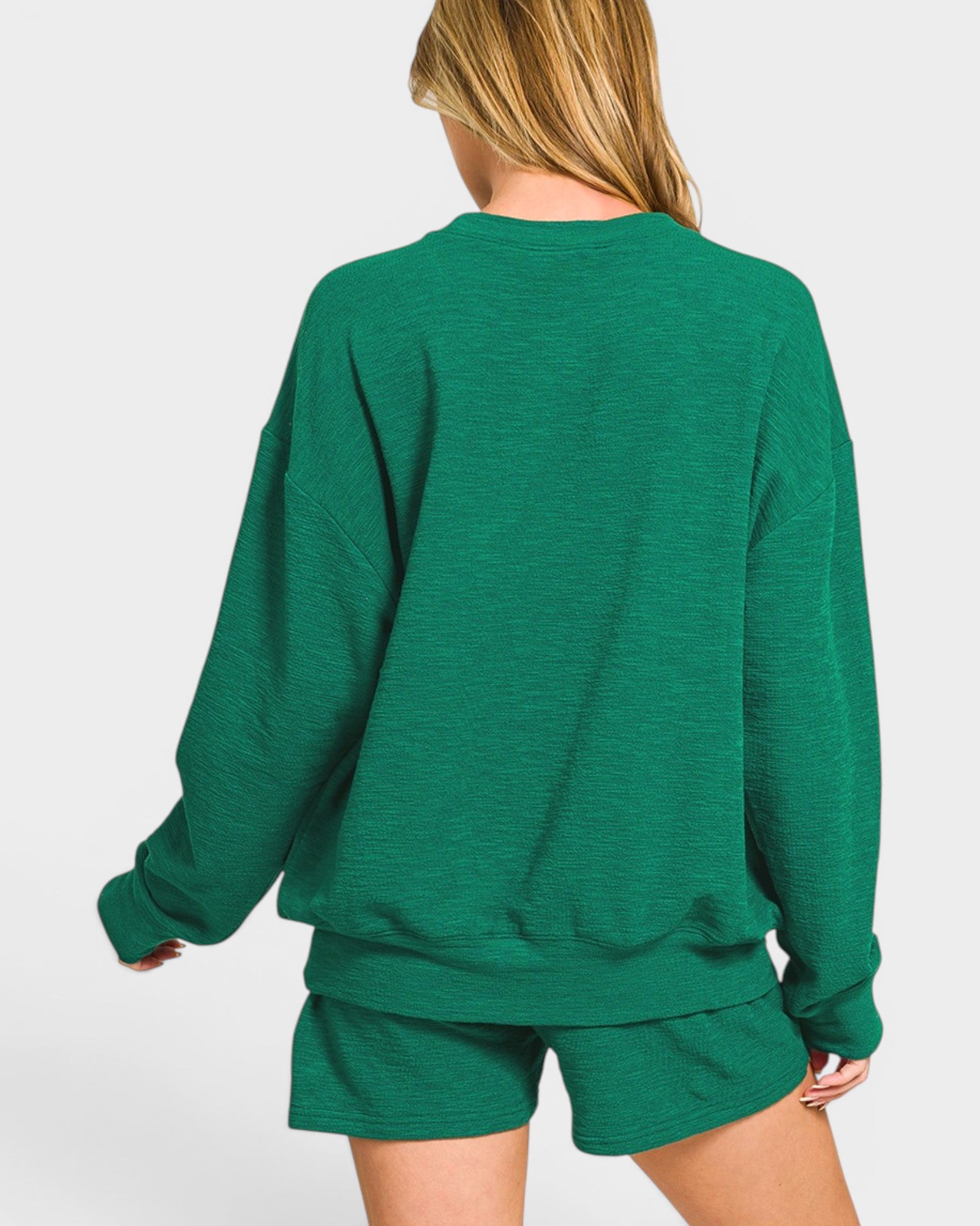 Green sweatshirt and shorts set on a white background