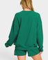 Green sweatshirt and shorts set on a white background