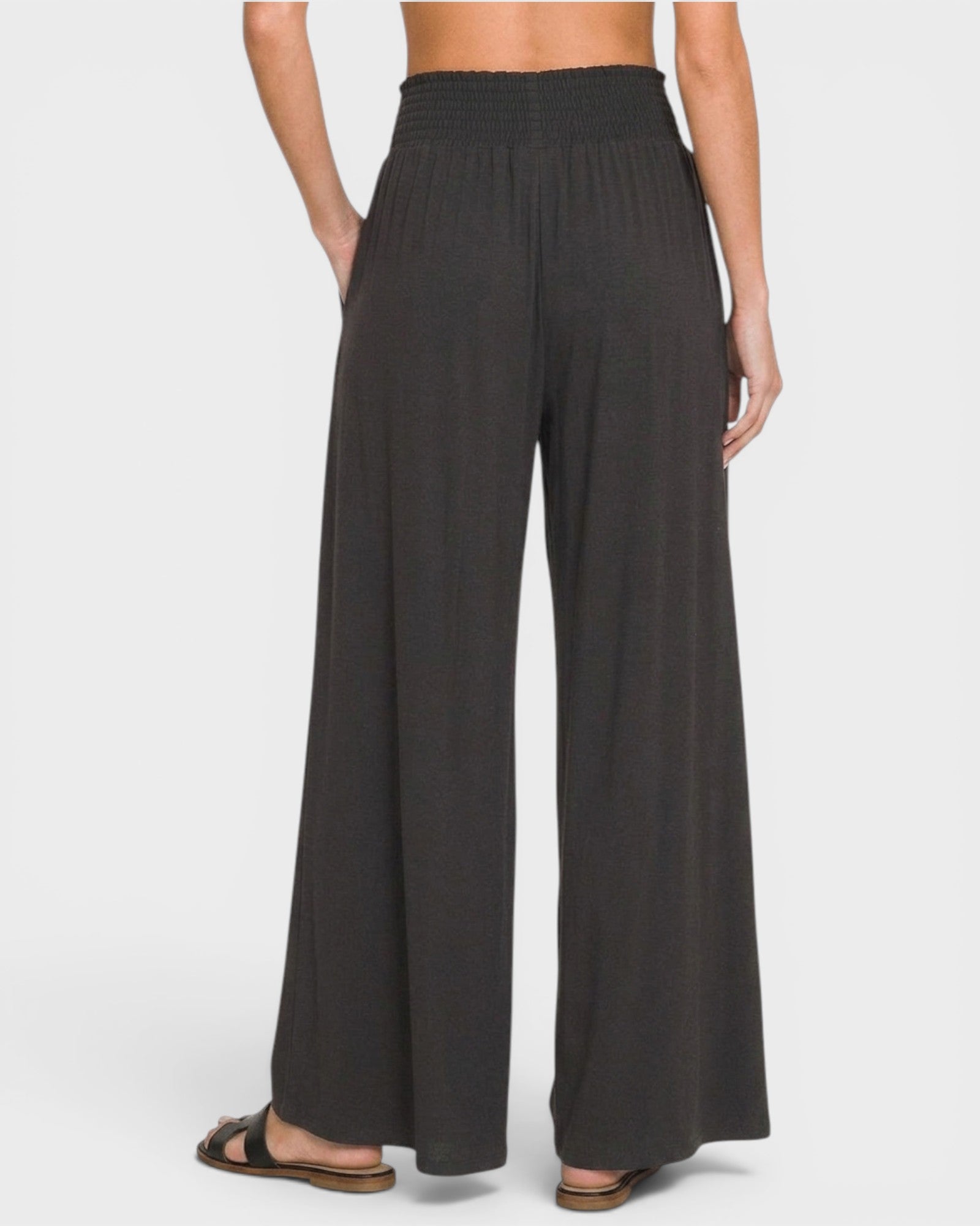 Black wide-leg pants worn by a person on a white background