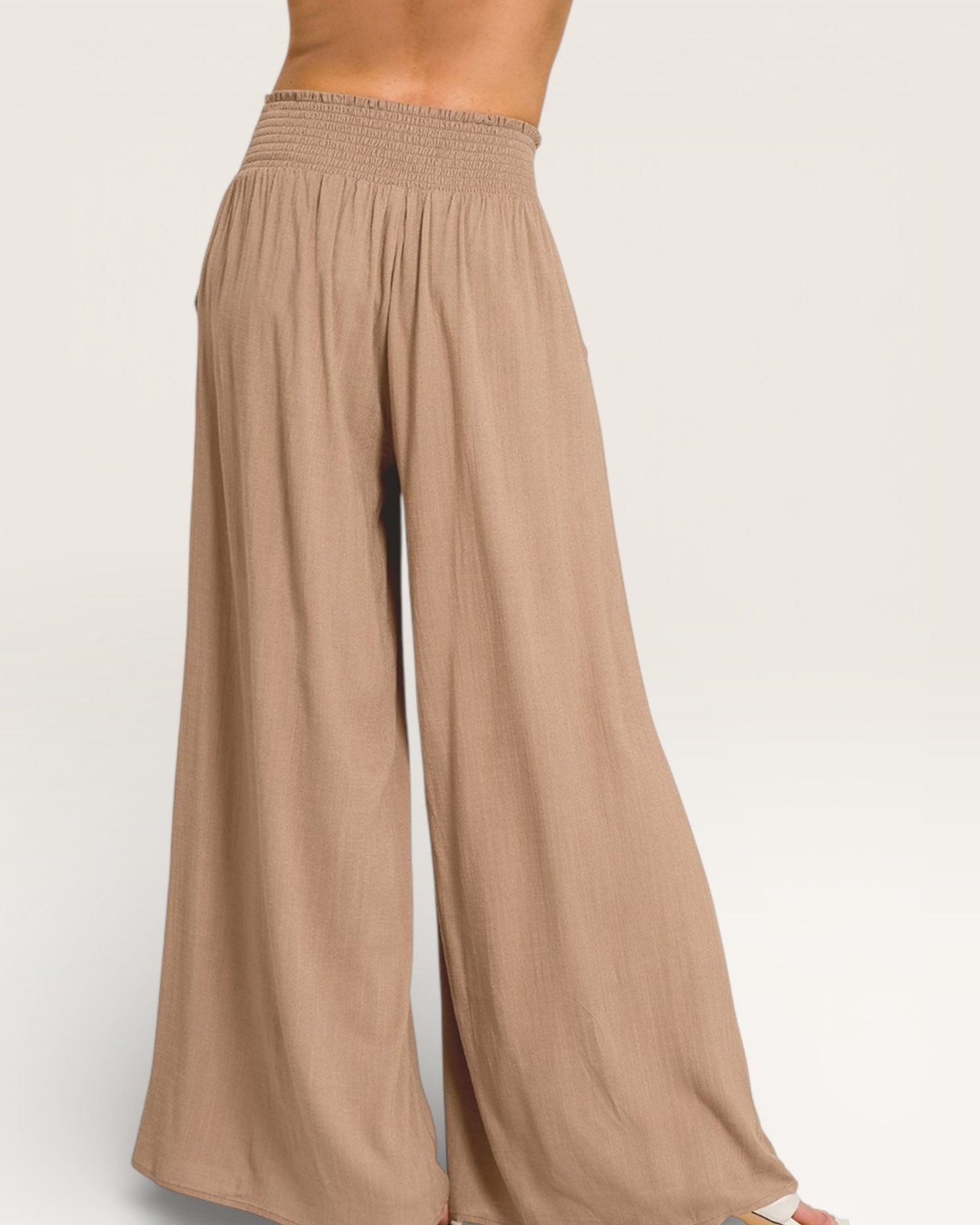 Beige wide-leg pants on a plain background