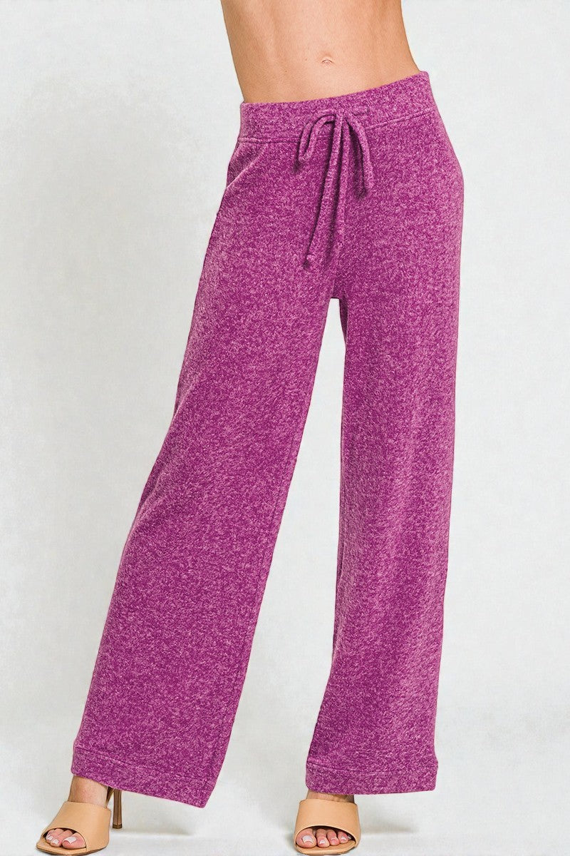 Purple drawstring pants on a white background