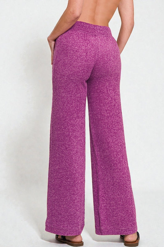 Purple wide-leg pants worn by a person on a white background