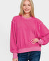 Woman wearing a pink sweatshirt on a plain background