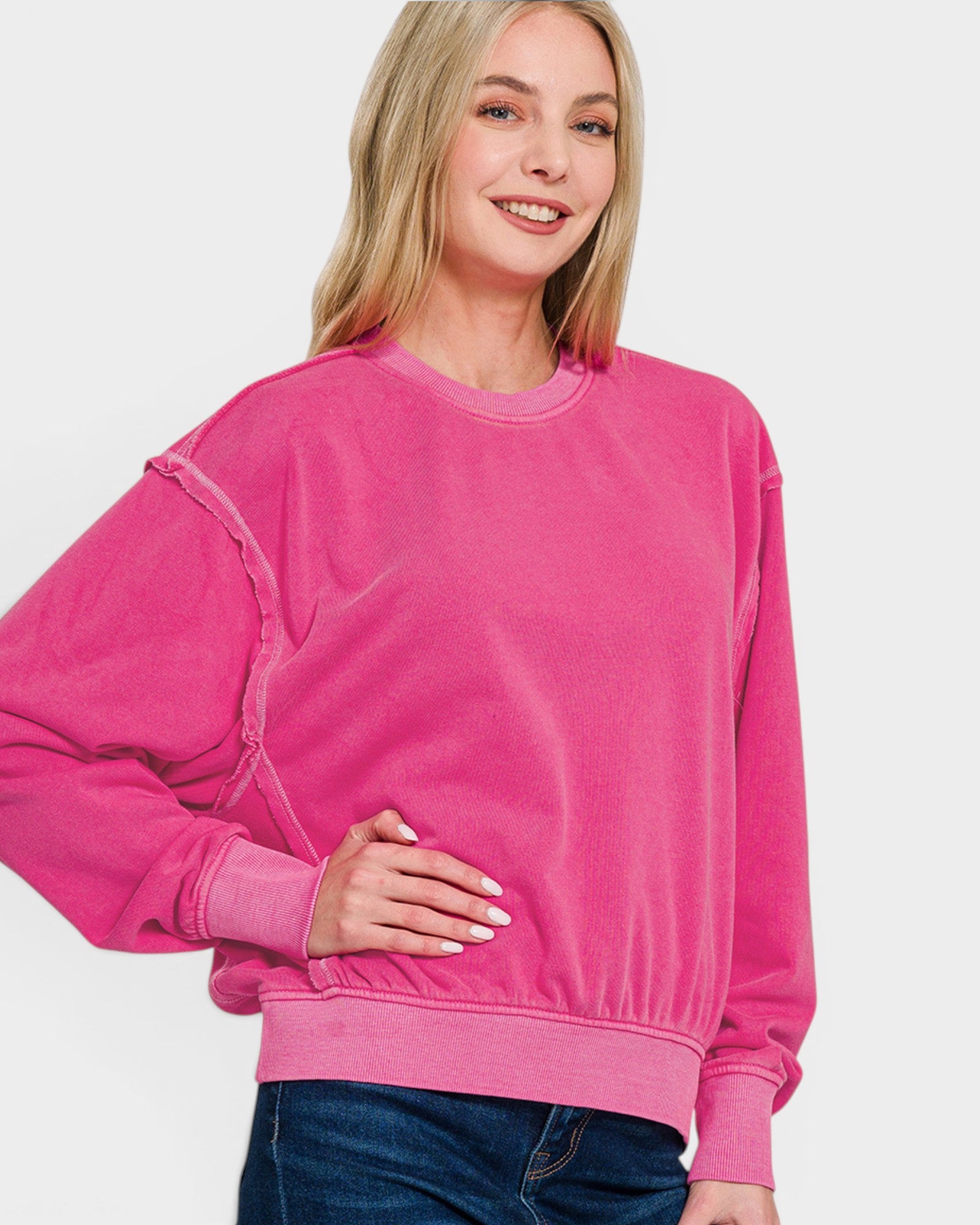 Woman wearing a bright pink sweatshirt on a white background