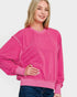 Woman wearing a bright pink sweatshirt on a white background