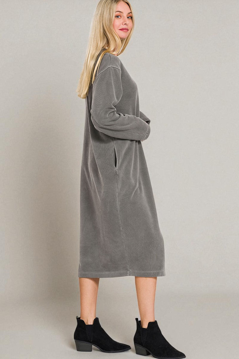 Woman wearing a gray dress against a plain background