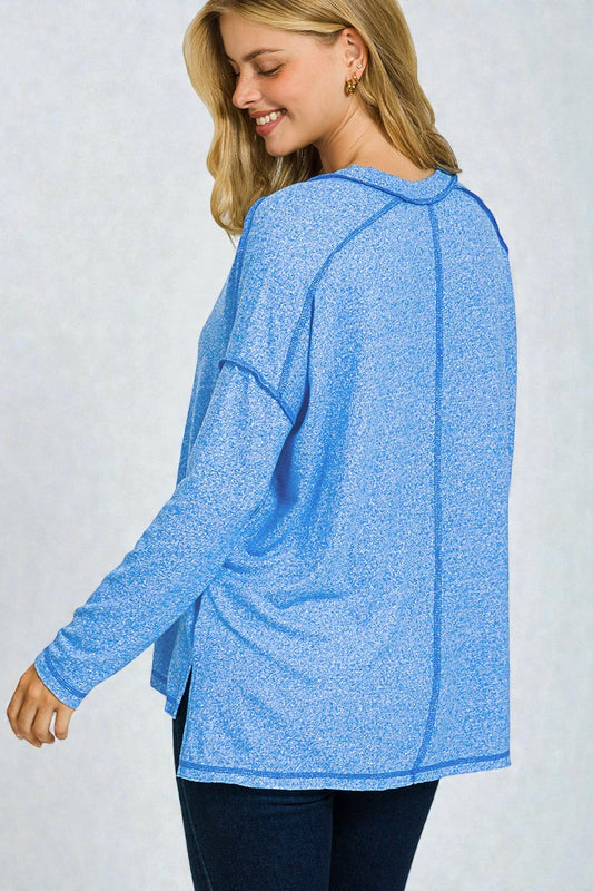 Woman wearing a blue long-sleeve top against a white background