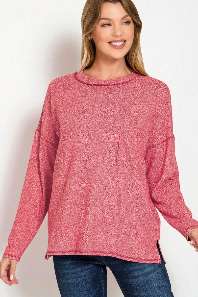 Woman wearing a pink long-sleeve top with a pocket on a white background