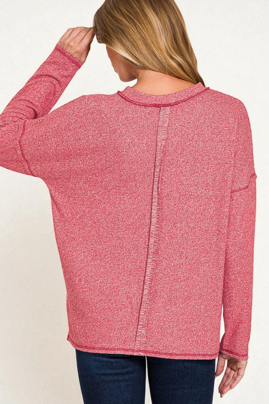 Person wearing a pink zip-up sweater on a white background