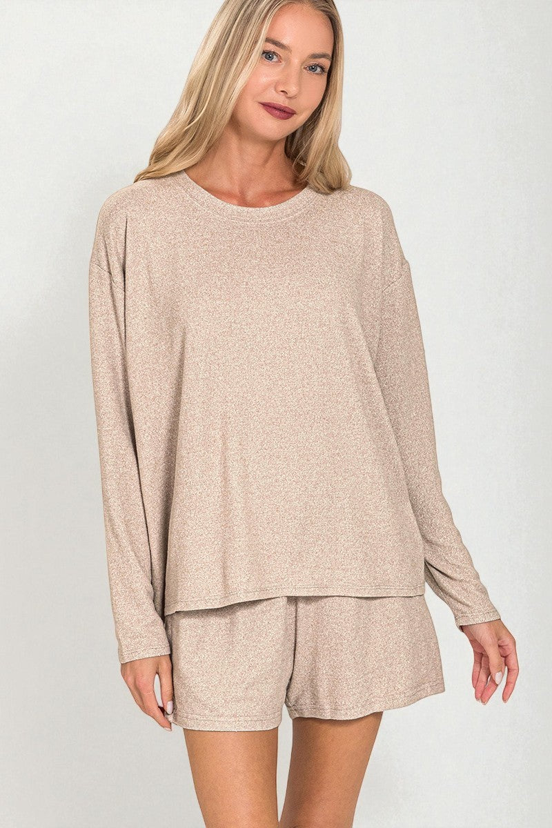 Woman wearing a beige long-sleeve top and shorts set on a white background