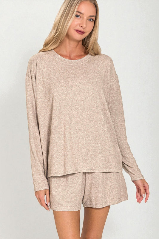 Woman wearing a beige long-sleeve top and shorts set on a white background