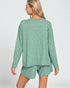 Woman wearing a green pajama set on a white background
