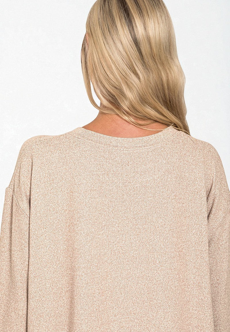 Beige sweater worn by a person with blonde hair on a white background