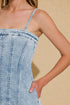 Denim dress worn by a person on a beige background