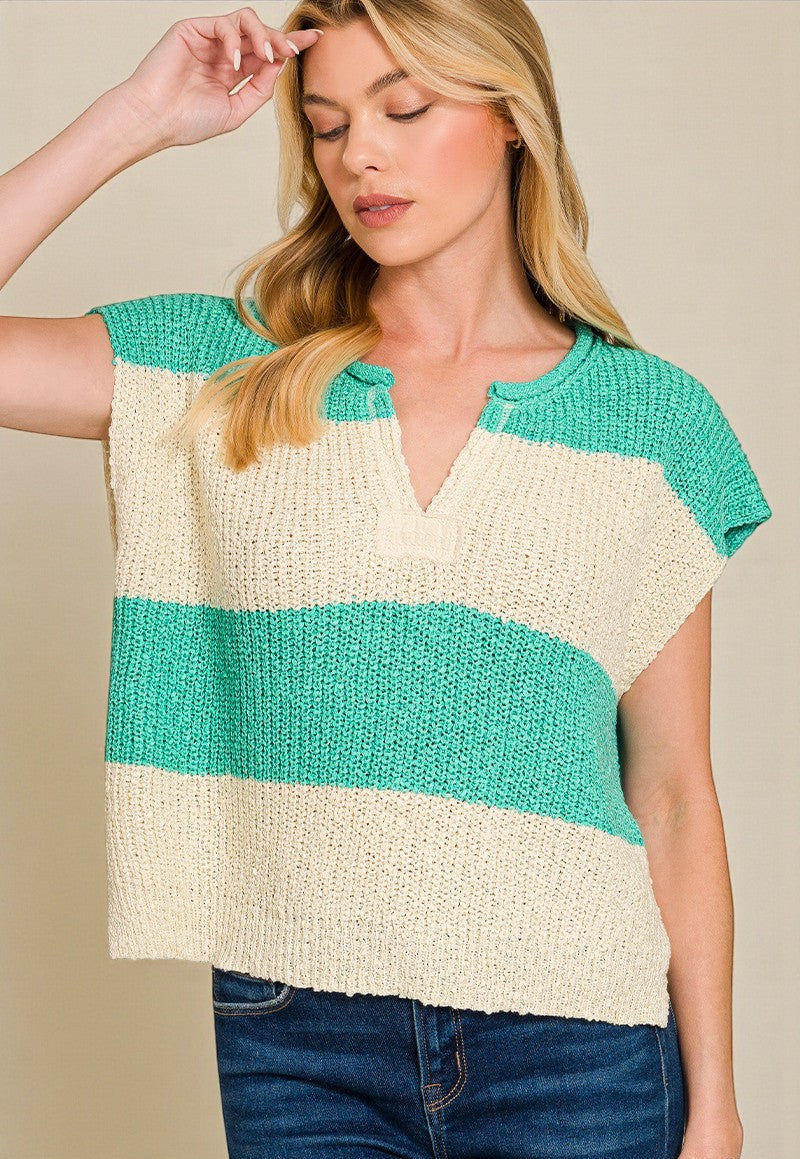 Woman wearing a sleeveless knitted top with green and beige stripes on a plain background