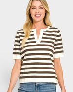 Woman wearing a brown and white striped shirt with a plain background