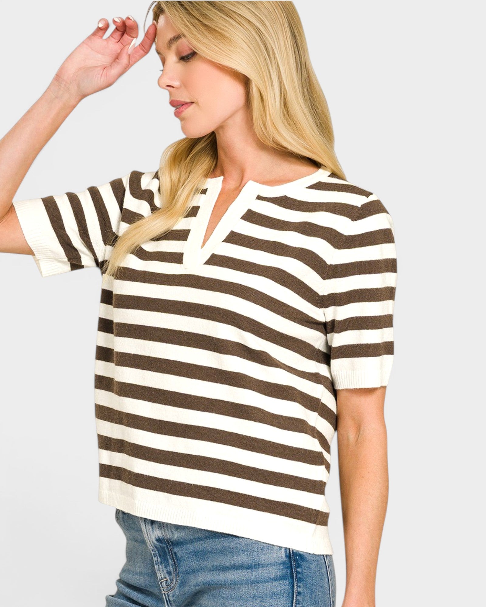Woman wearing a brown and white striped shirt with a plain background