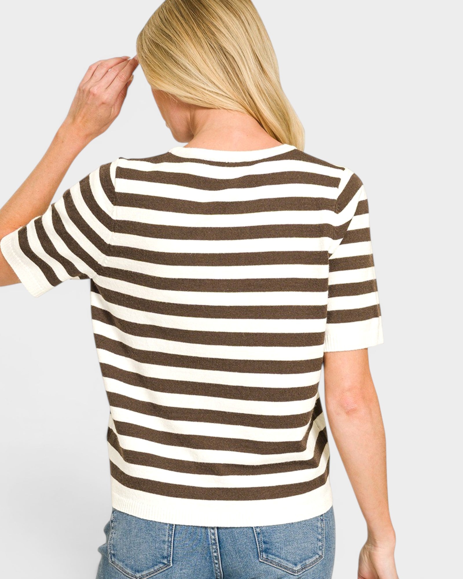Person wearing a brown and white striped shirt on a plain background