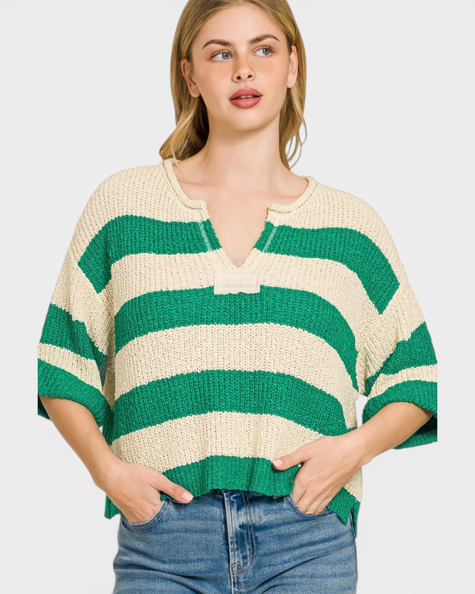Woman wearing a green and beige striped sweater on a white background