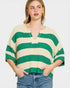 Woman wearing a green and beige striped sweater on a white background
