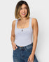 Woman wearing a gray tank top and blue jeans against a white background
