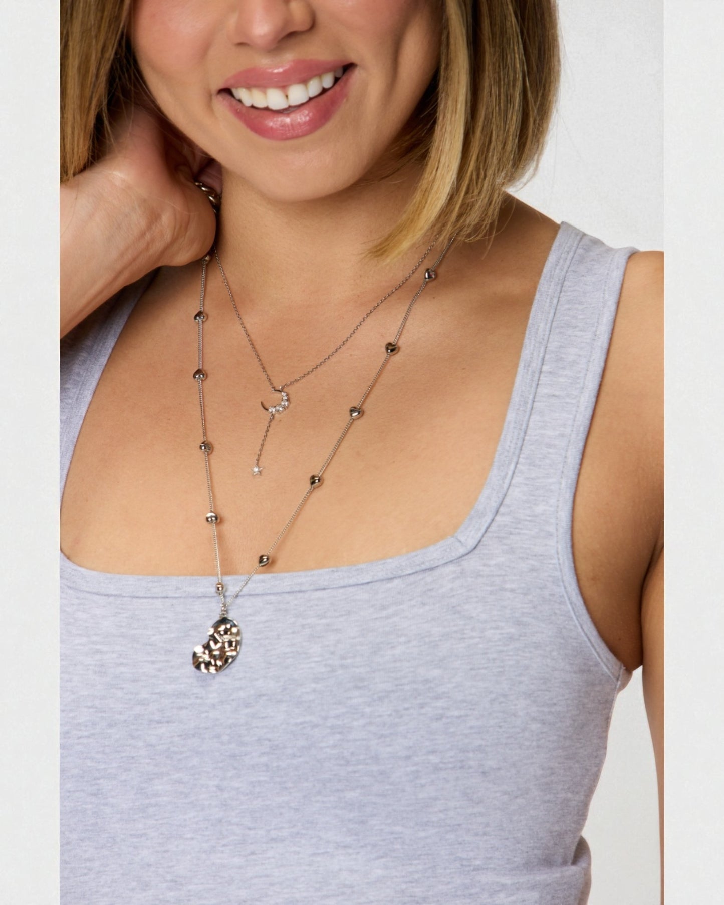 Woman wearing a necklace with a plain background