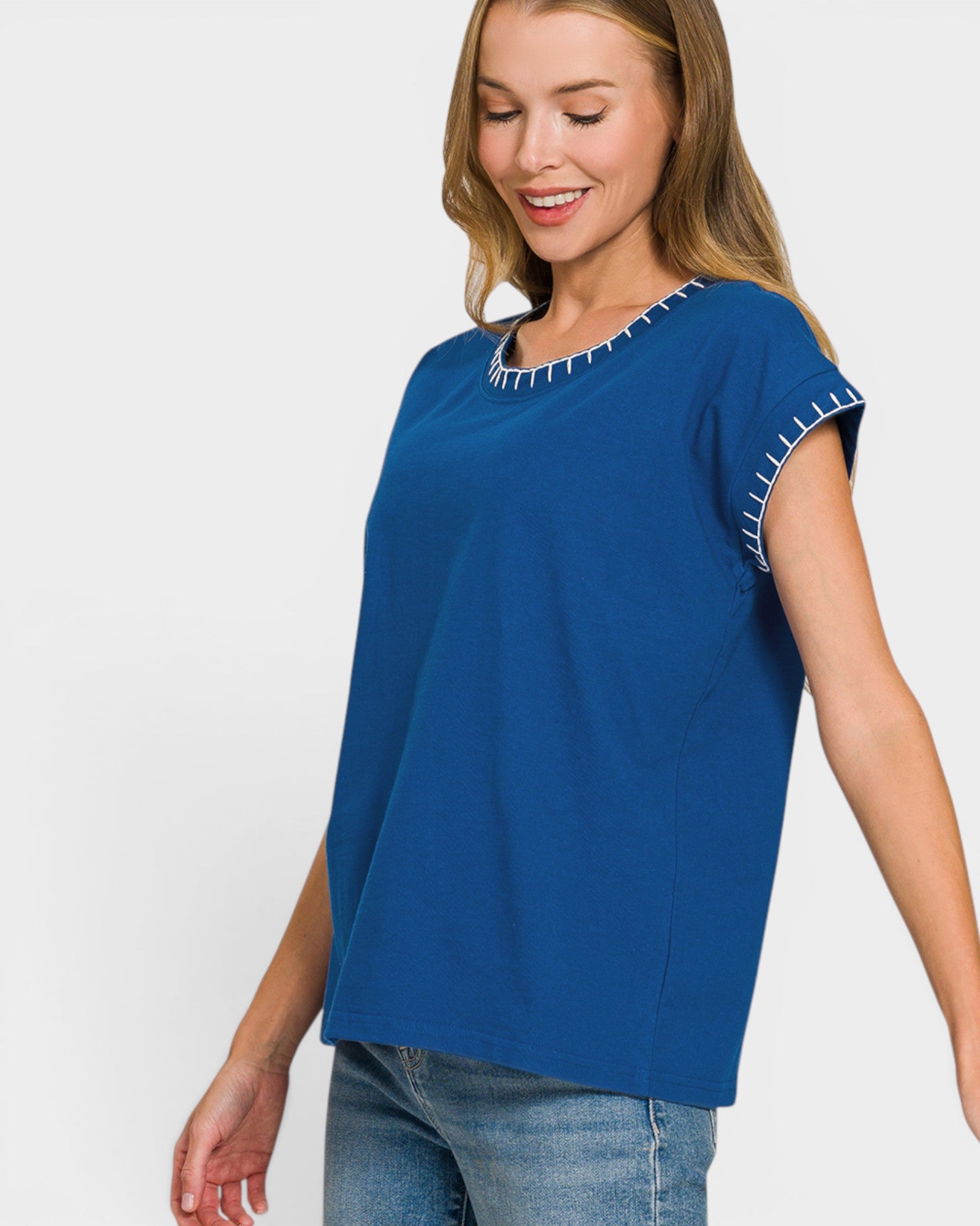 Woman wearing a blue top with white trim on a white background