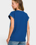 Woman wearing a blue top with white trim on a plain background
