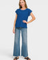 Woman wearing a blue top and light blue jeans on a white background