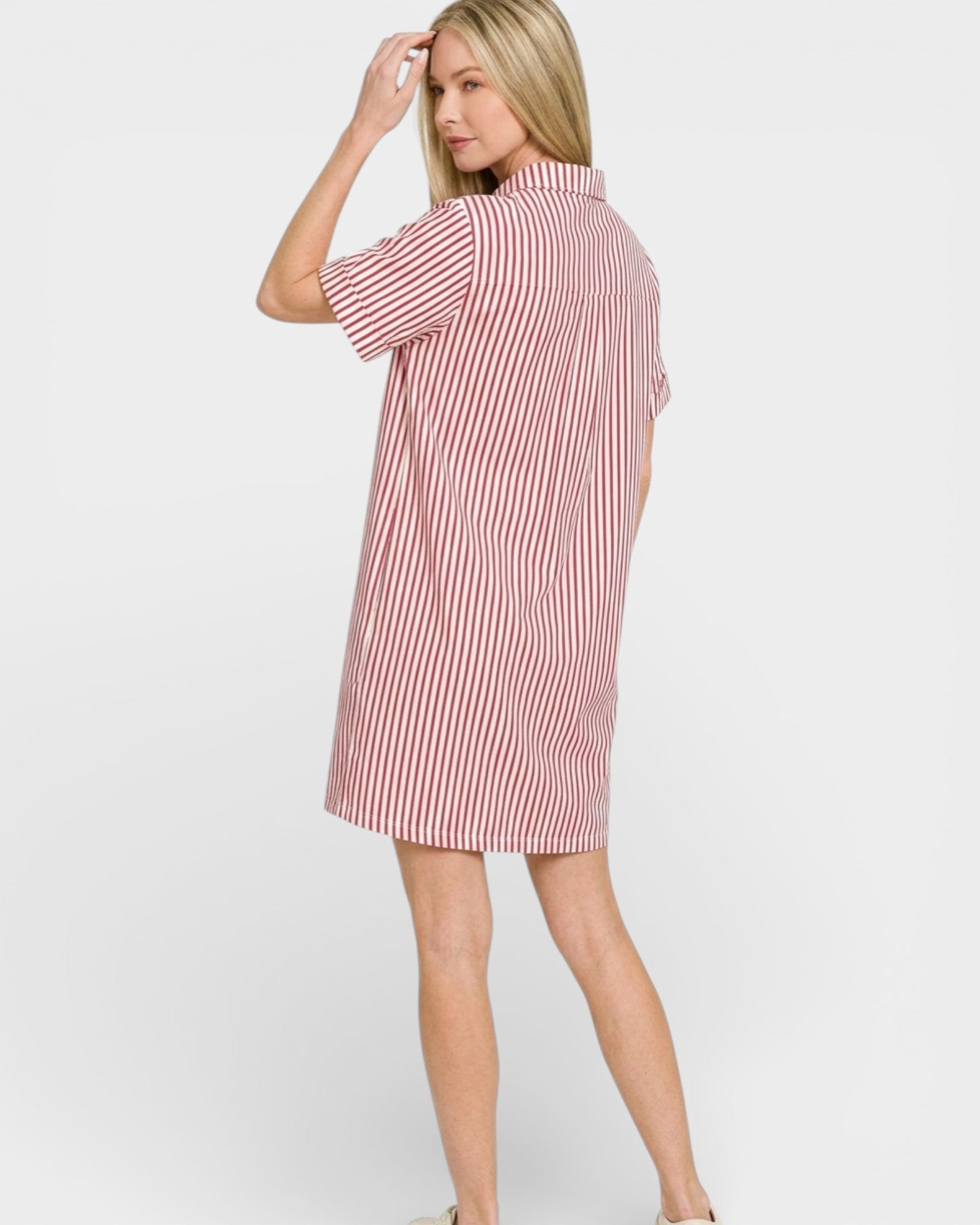 Woman wearing a red and white striped dress on a white background