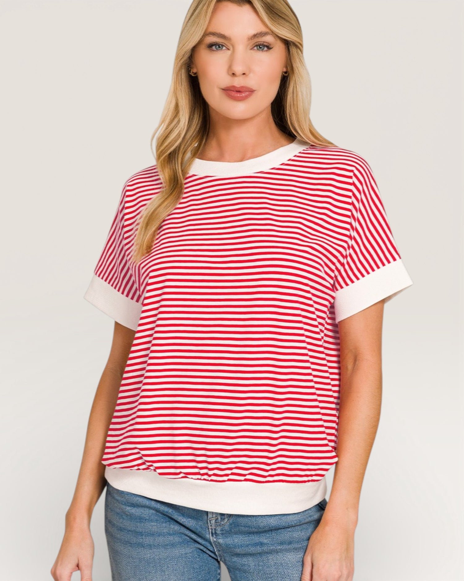 Woman wearing a red and white striped shirt with a plain background