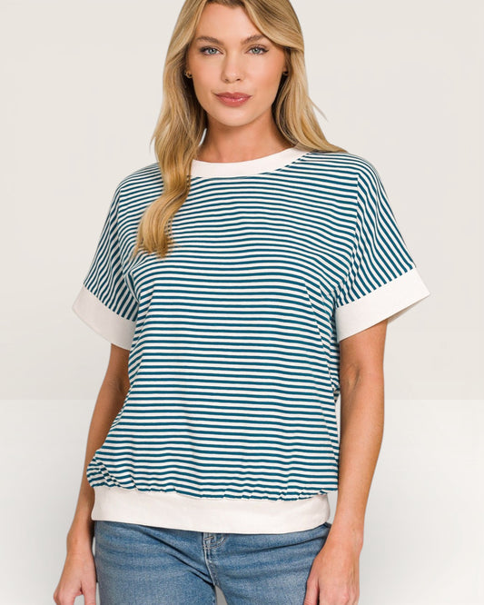 Woman wearing a blue and white striped shirt with a plain background