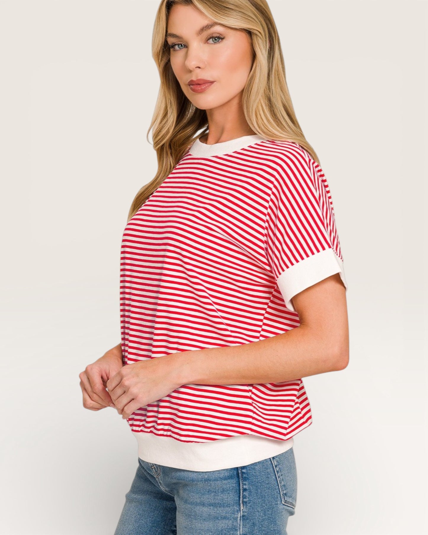Woman wearing a red and white striped shirt with a plain background