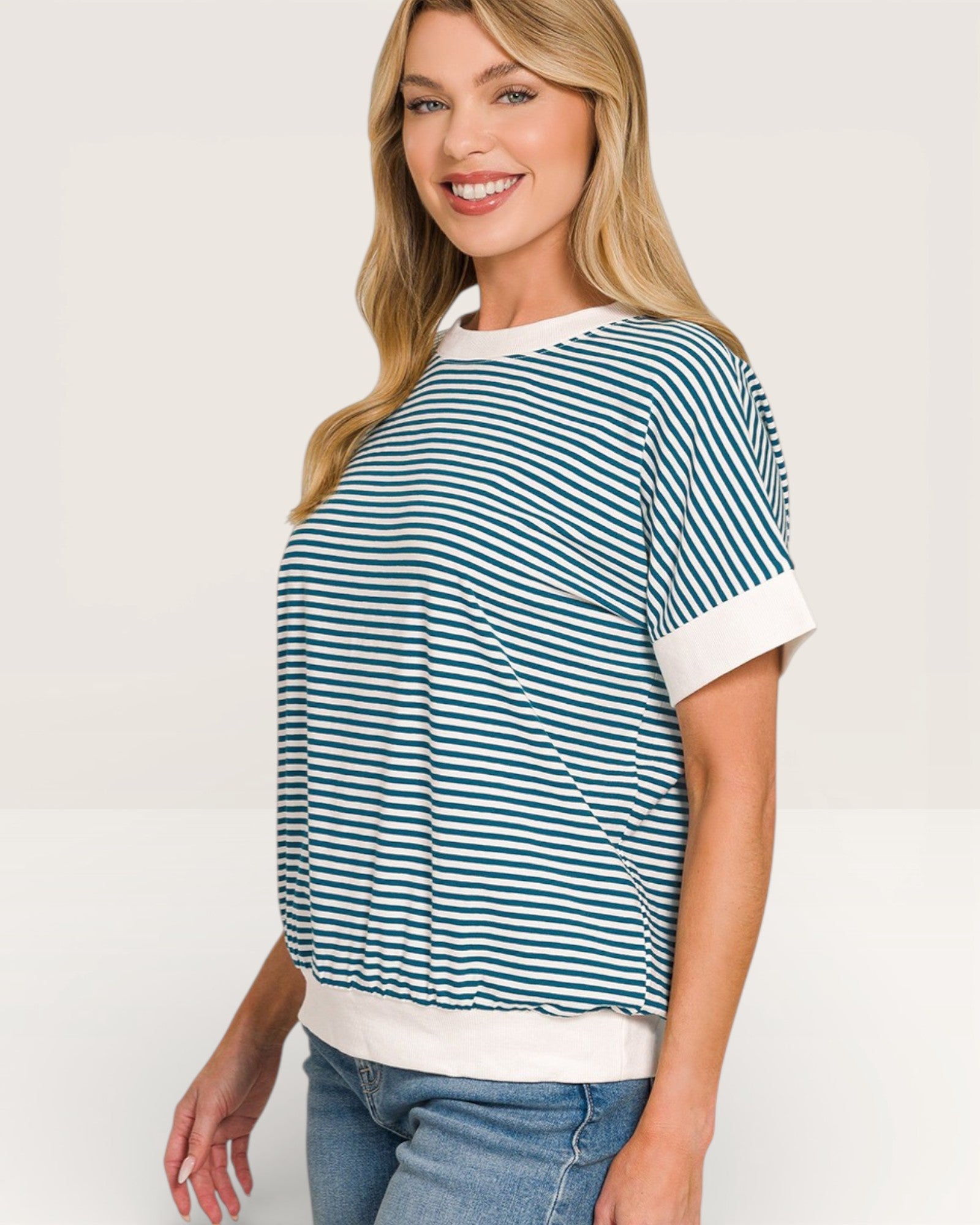 Woman wearing a green and white striped shirt on a plain background