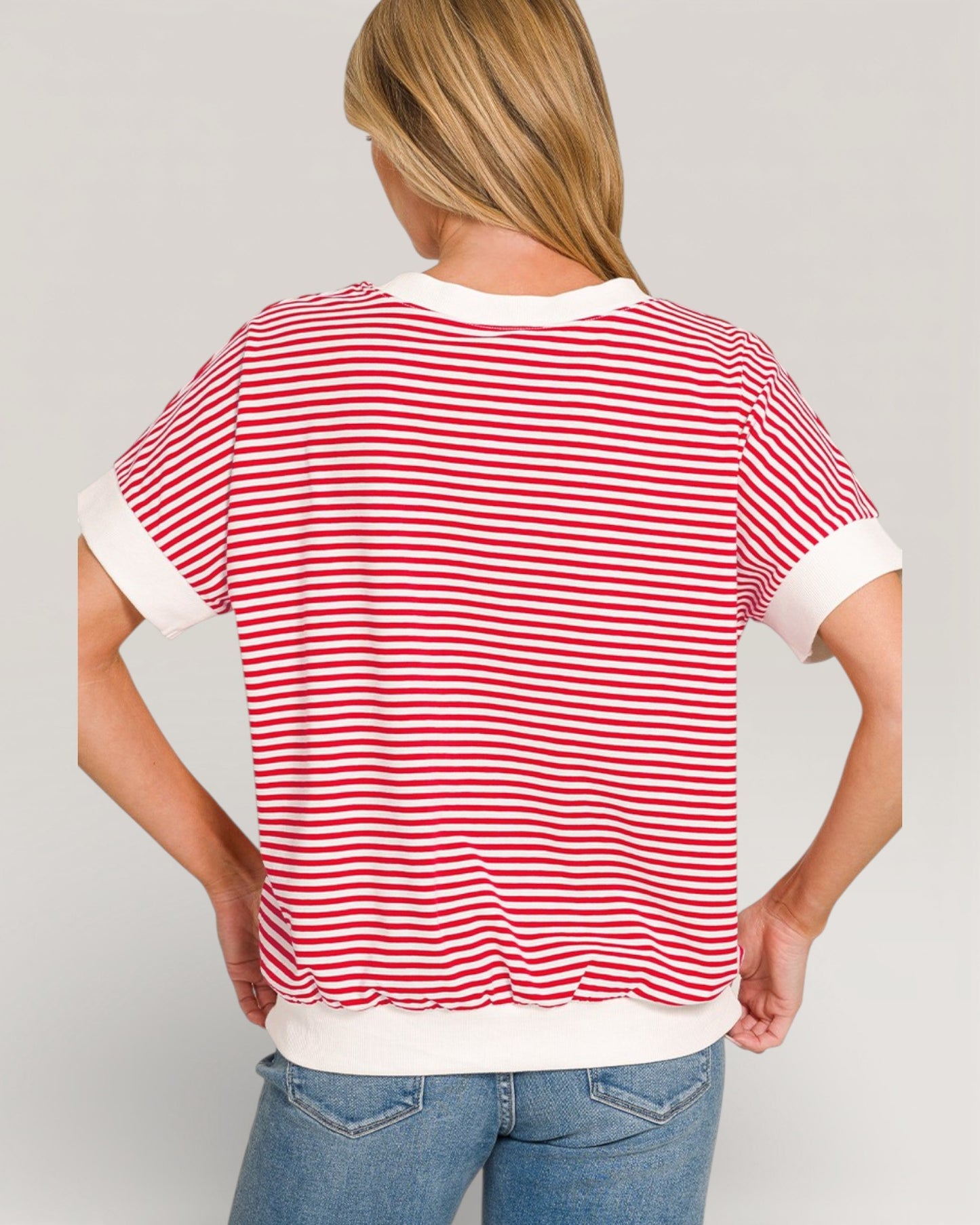 Person wearing a red and white striped shirt with a plain background