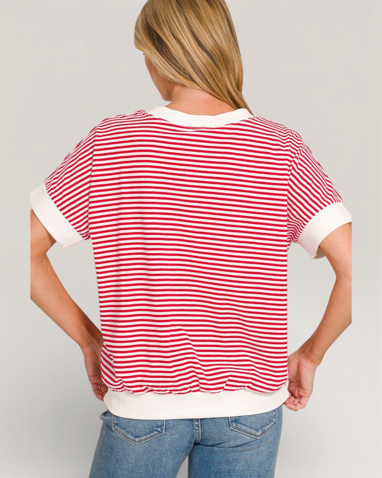 Person wearing a red and white striped shirt with a plain background