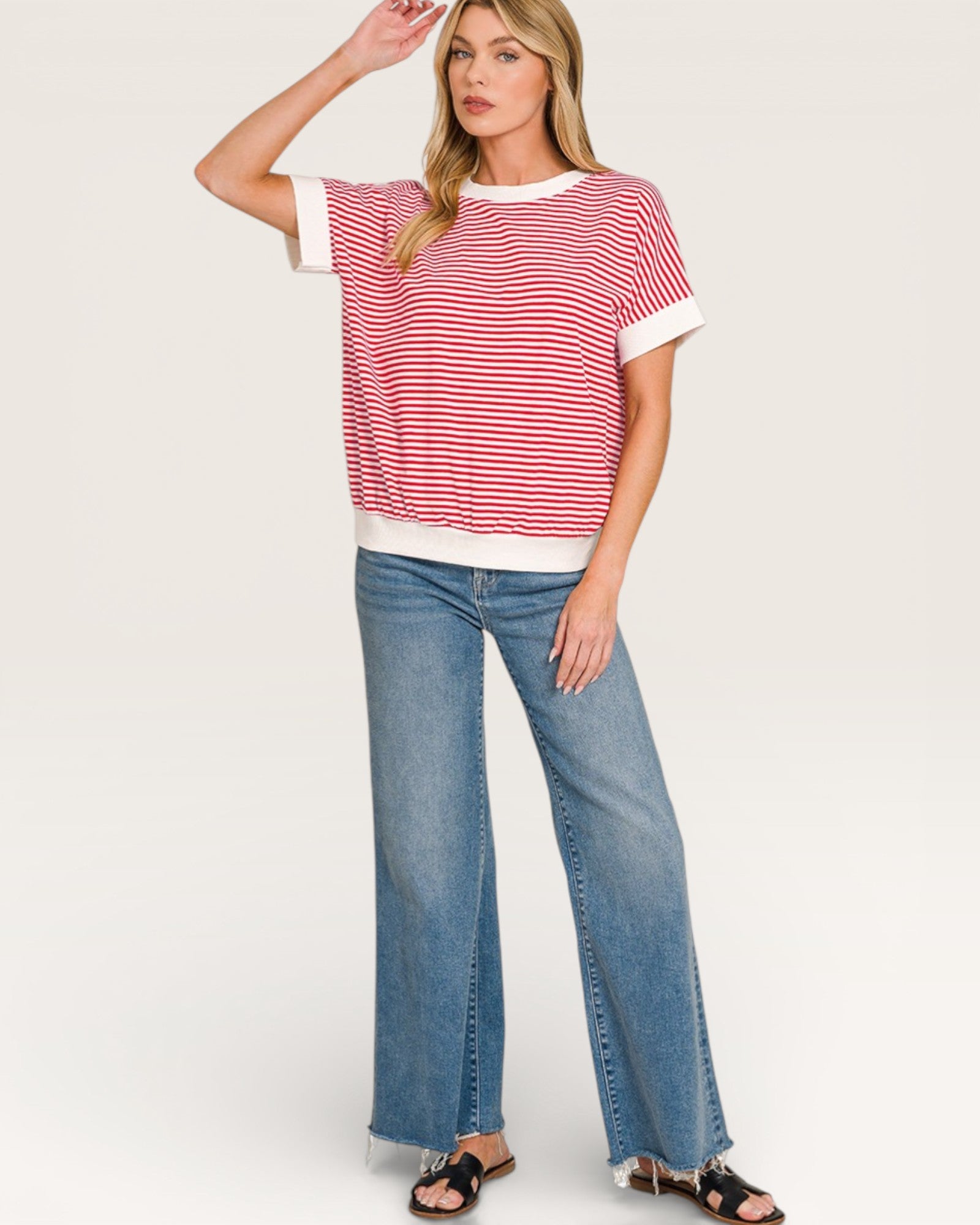 Woman wearing a red and white striped shirt and blue jeans on a white background