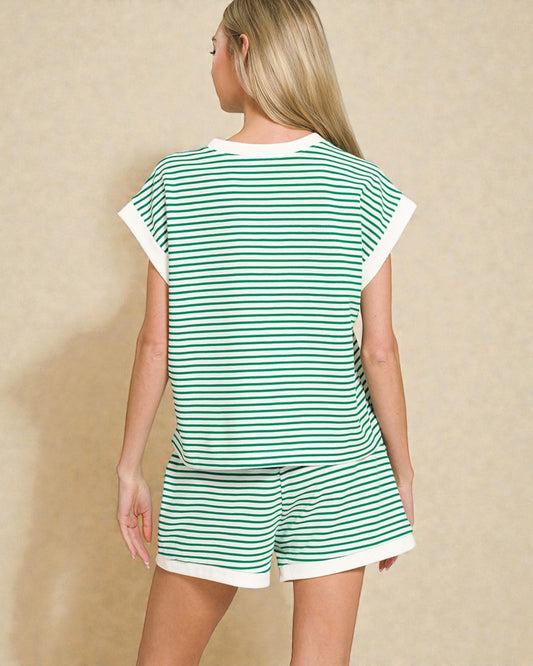 Woman wearing a green and white striped outfit on a beige background
