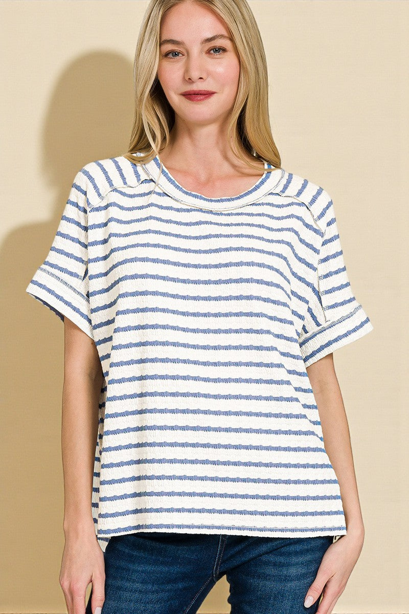 Woman wearing a blue and white striped t-shirt against a beige background