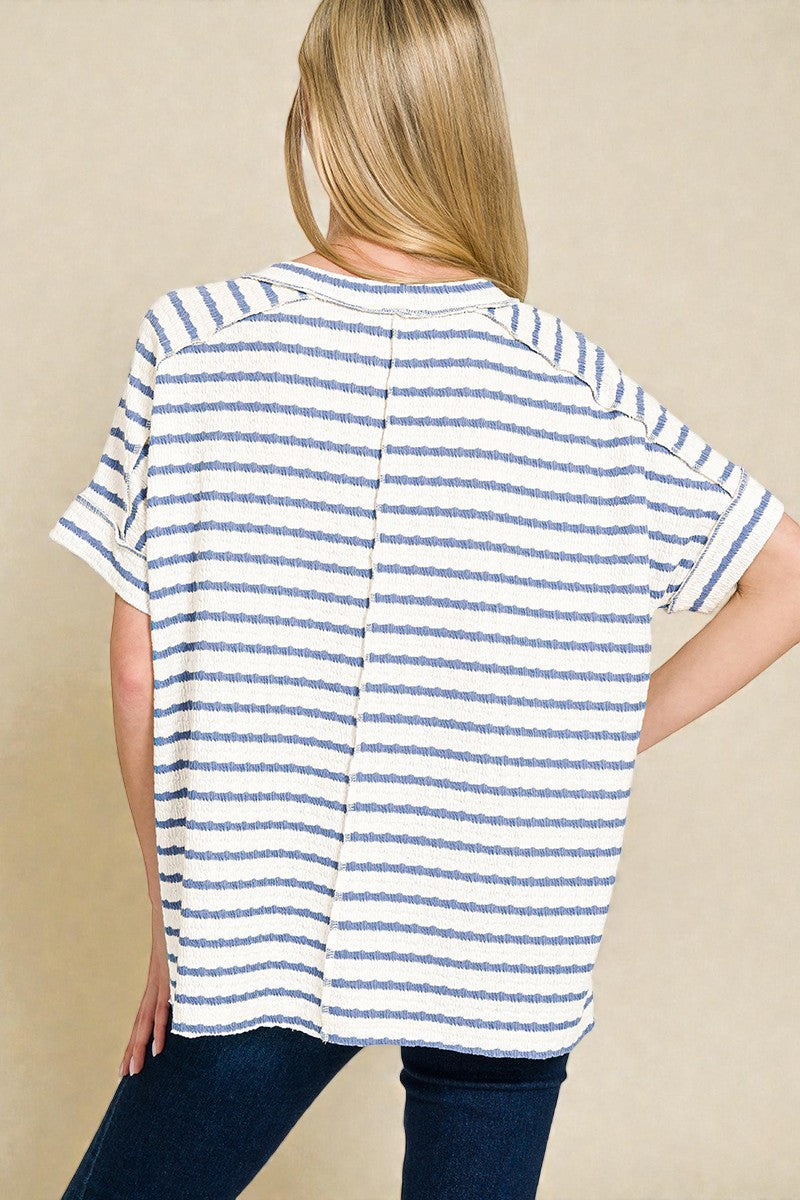Person wearing a blue and white striped shirt on a beige background