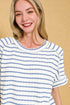 Woman wearing a blue and white striped shirt against a beige background