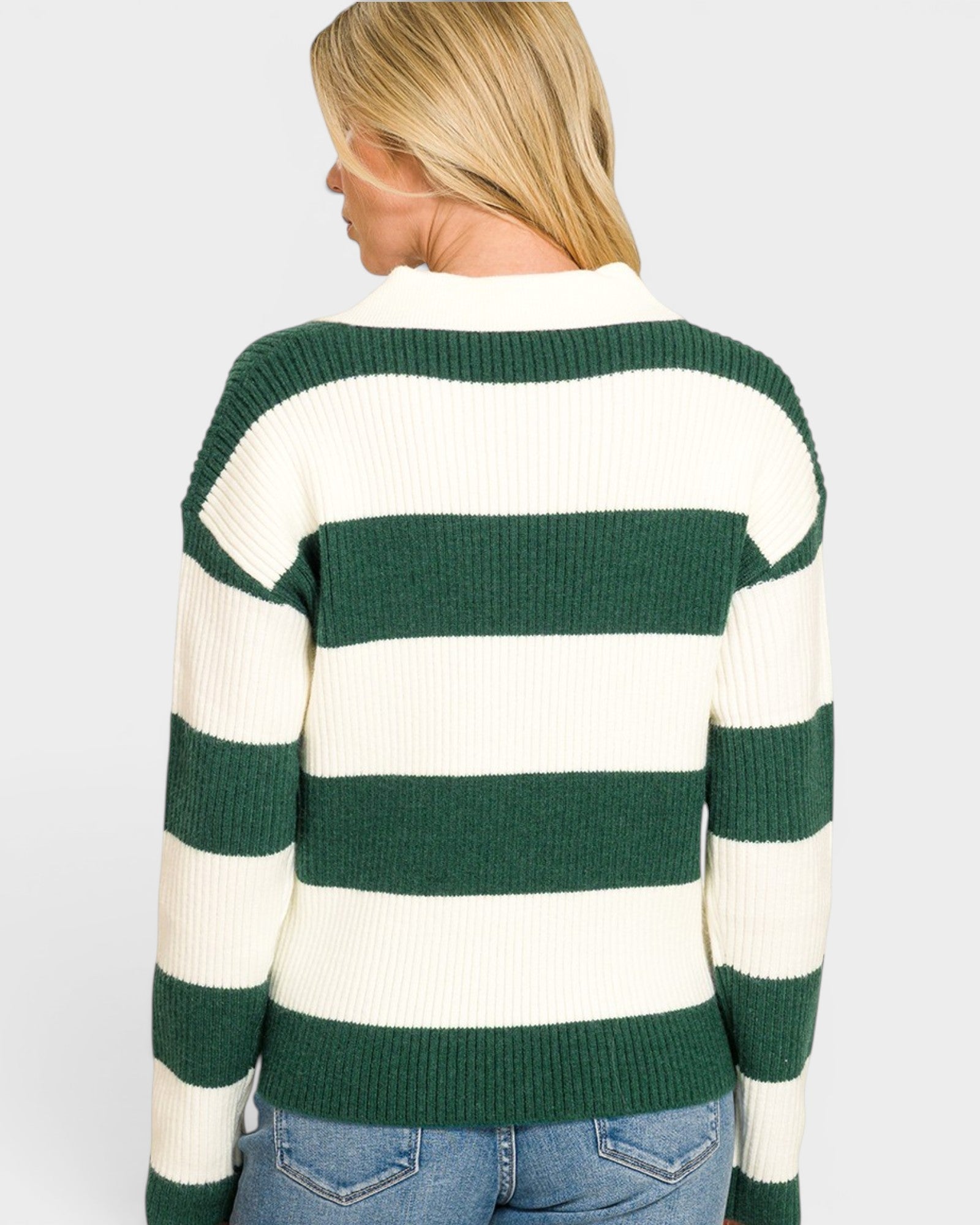 Person wearing a green and white striped sweater on a plain background