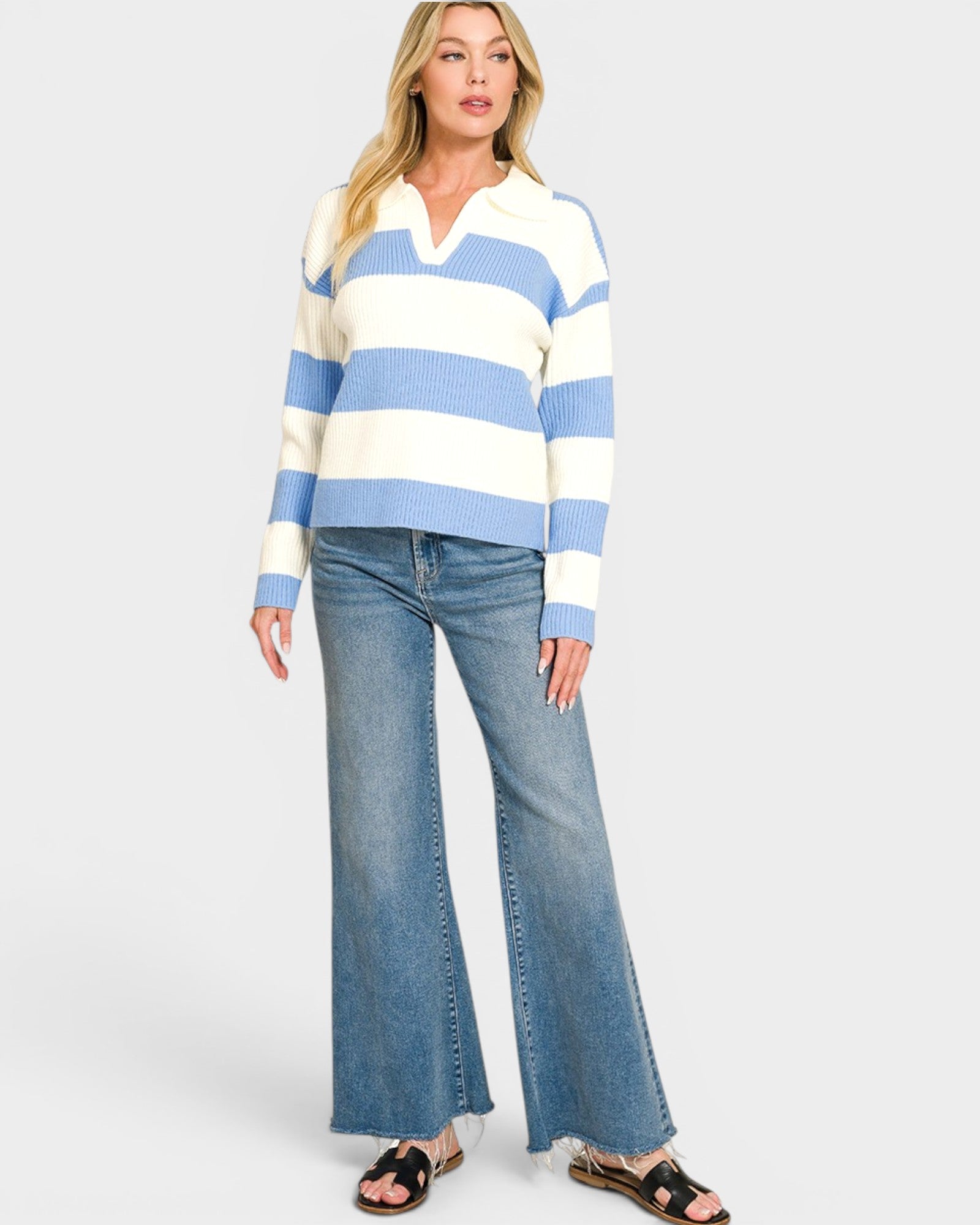 Woman wearing a blue and white striped sweater and blue jeans on a white background