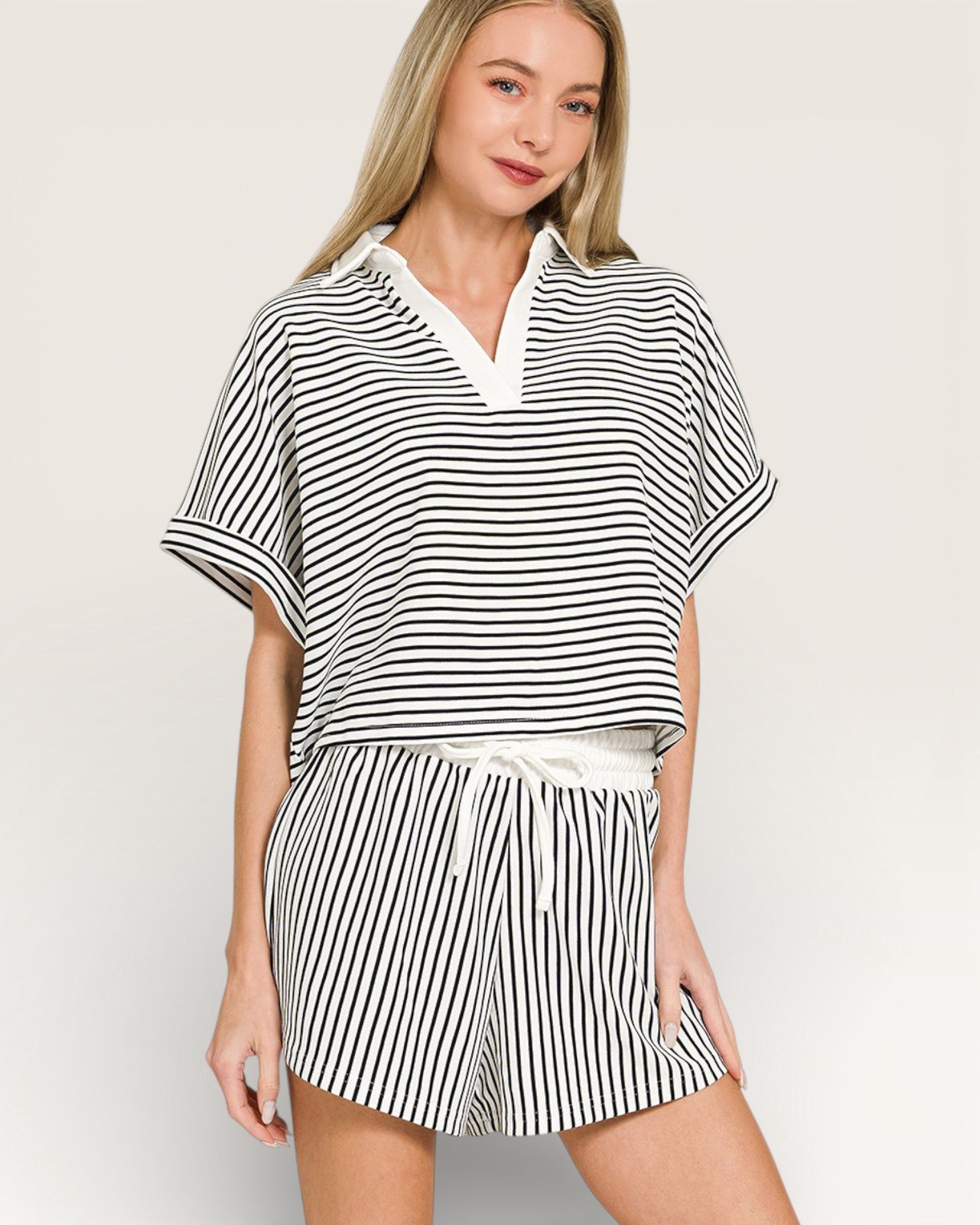 Woman wearing a black and white striped outfit on a plain background