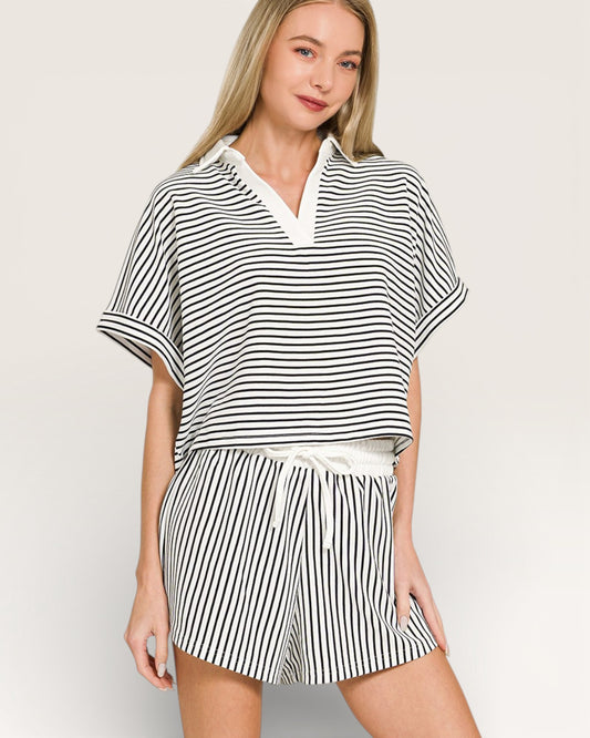 Woman wearing a black and white striped outfit on a plain background